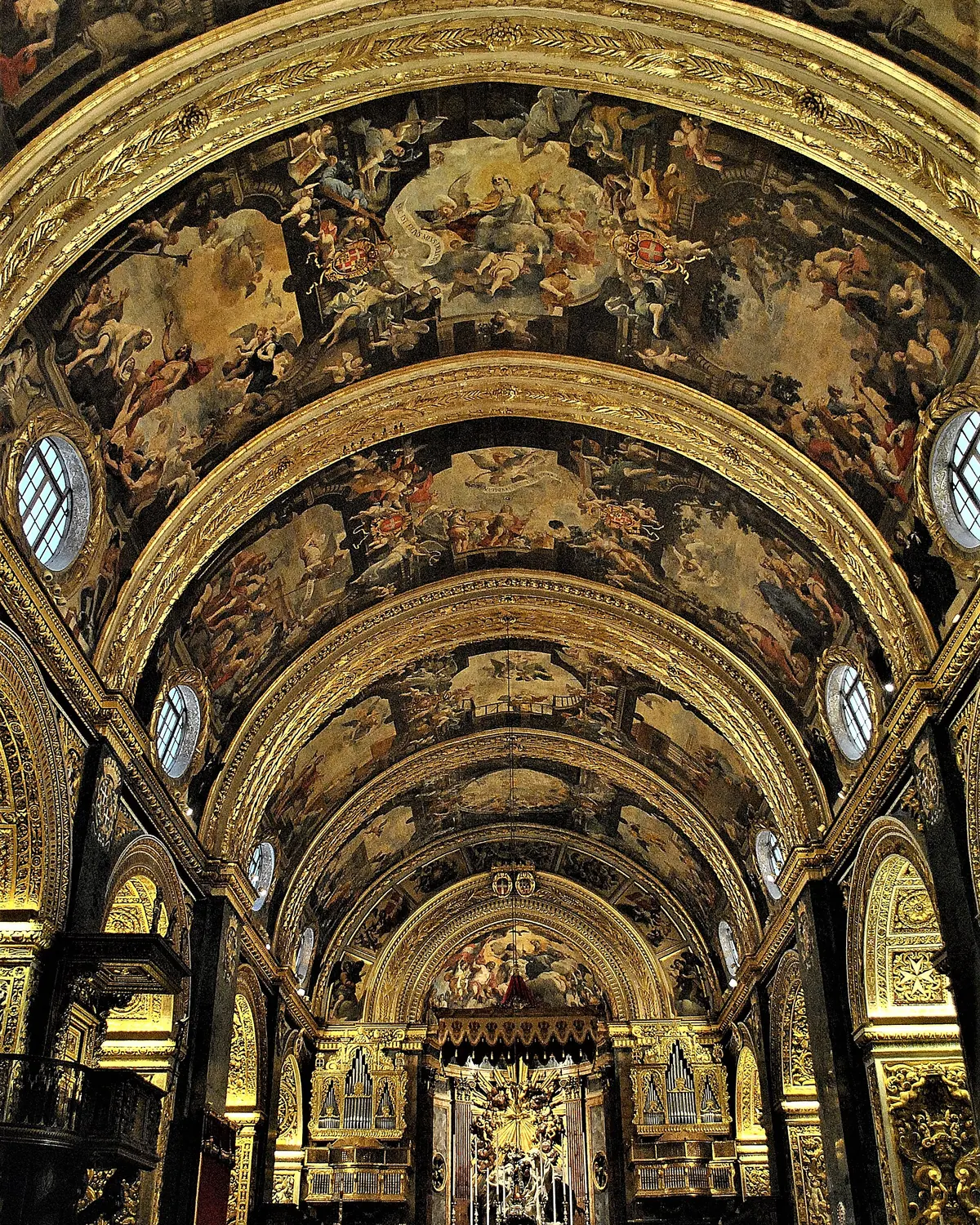 The painted barrel vault of St John's Co-Cathedral seen from below, with gilded ribs framing scenes from the life of Saint John the Baptist